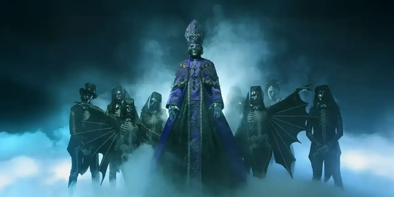 Le groupe de musique Ghost, avec son leader en tenue papale violette, entouré de musiciens aux costumes squelettiques et masqués, émerge d'une brume bleutée.