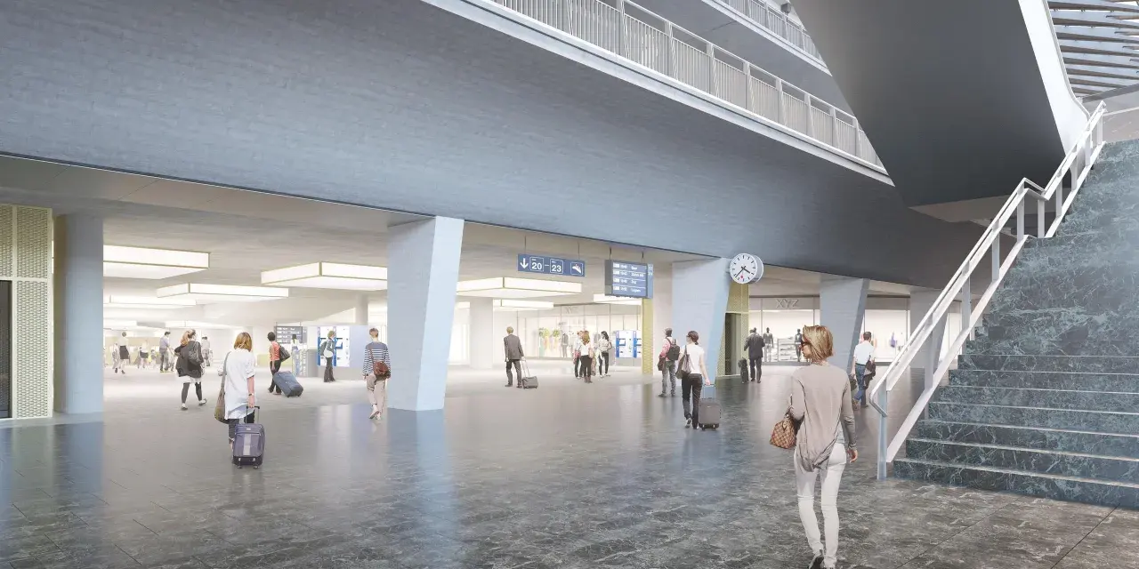 Modern, spacious interior of the Lucerne train station with travelers and digital departure boards.