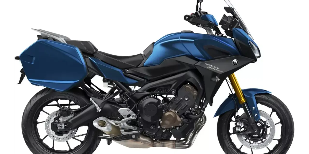 Niebieski motocykl Yamaha Tracer 900 GT z kuframi, gotowy na dalekie podróże.