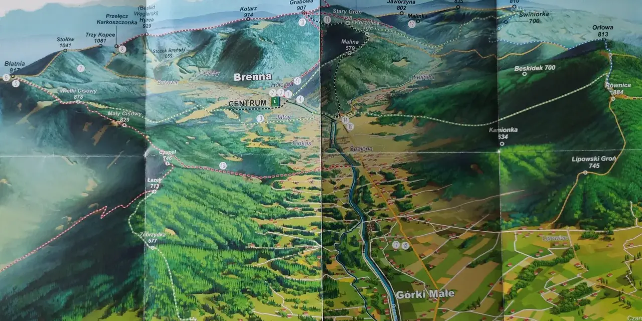 Mapa turystyczna z zaznaczonymi szlakami z Brennej. Widok na góry, lasy i doliny z wioskami.