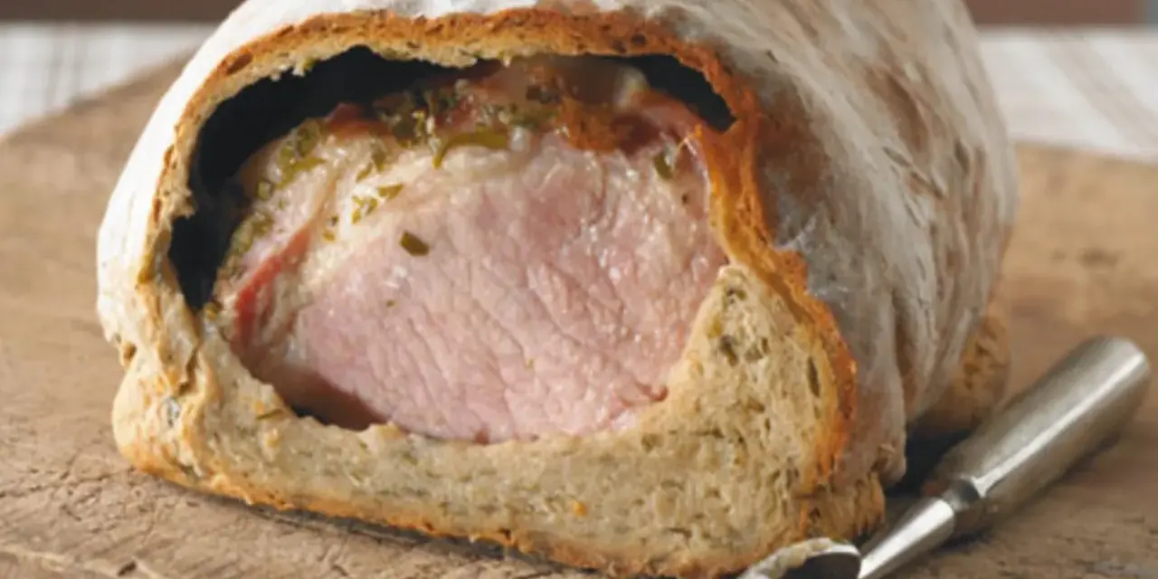 Saftiges Kassler im knusprigen Brotmantel, bereit zum Anschneiden. Ein Festmahl!