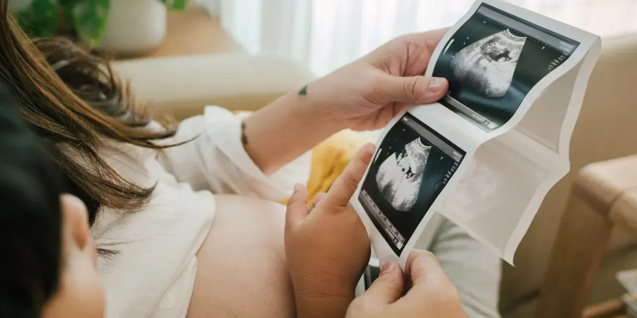 Rodzice oglądają USG. Na zdjęciu widać zarodek, który ma już 11 tydzień ciąży.