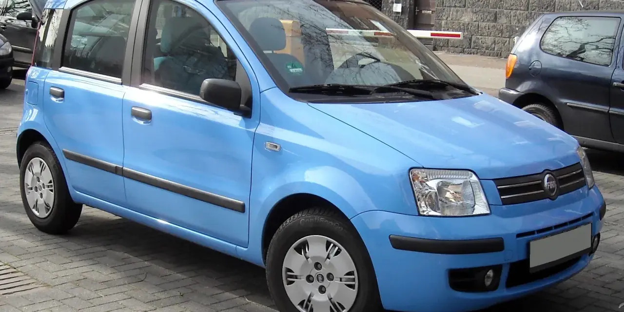 Una Fiat Panda blu parcheggiata su un selciato. Il suo peso è ideale per la città.