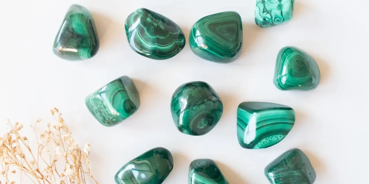 Tumbled malachite stones with their characteristic green bands, showcasing the beauty and potential malachite proprietà.