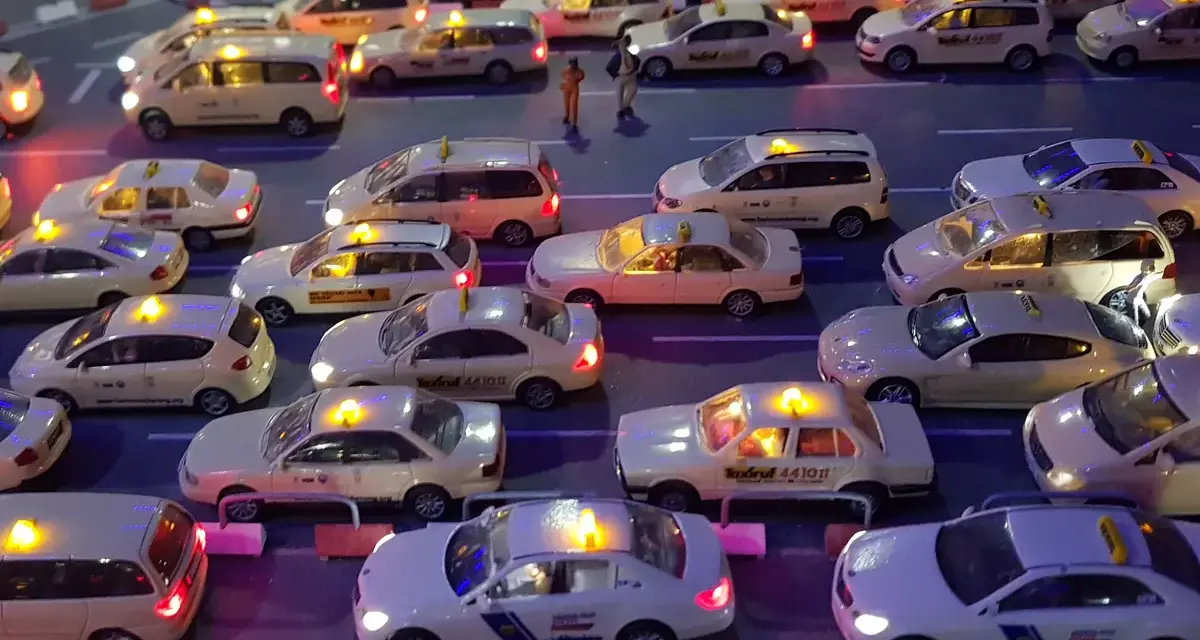 Modellautos von Taxis stehen im Stau. Die Lichter leuchten, als ob sie Nachtzuschlag berechnen würden.
