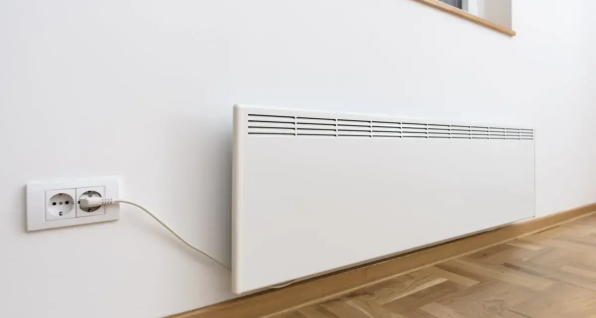 Termoconvettori bianchi montati a parete, uno collegato a una presa elettrica, pronti a riscaldare l'ambiente.