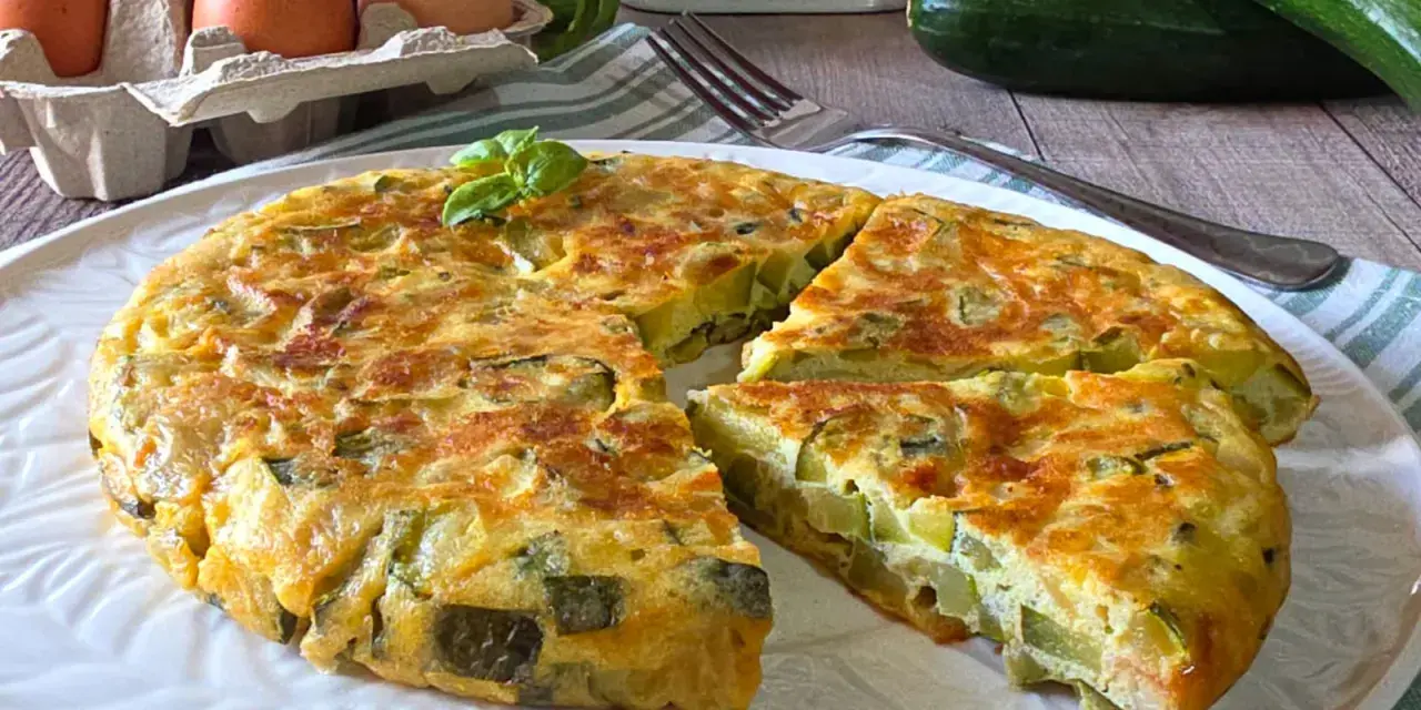 Una gustosa frittata di zucchine, dorata e soffice, con zucchine fresche, uova e basilico. Perfetta per un pasto leggero.
