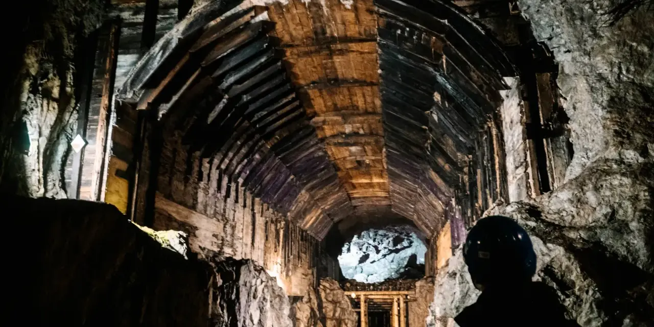 Wnętrze kopalni, gdzie poszukiwane są skarby Gór Sowich. Drewniane wzmocnienia tunelu i skalne ściany tworzą mroczną atmosferę.