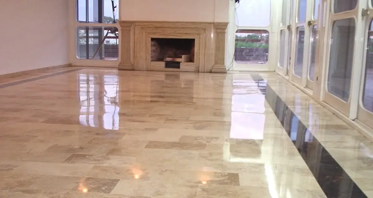 Pavimento in marmo beige con finitura a specchio, che riflette le luci e le finestre. Un lavoro di lucidatura perfetto per un ambiente elegante.