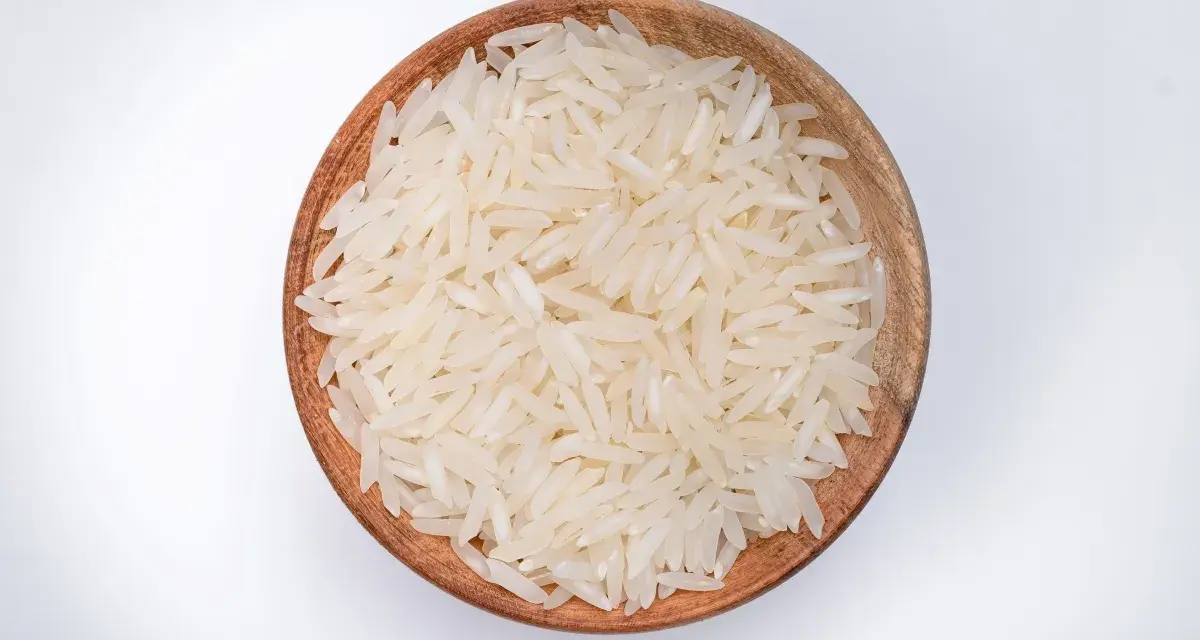 Miseczka z ryżem parboiled na białym tle.