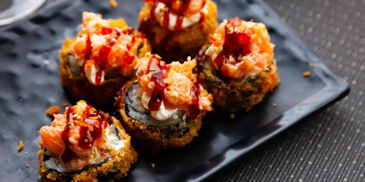 Pięć kawałków sushi w tempurze z łososiem i sosem, idealne na przekąskę.