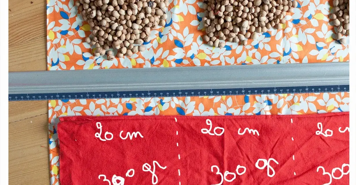 Préparation d'une bouillotte aux noyaux de cerise. Quel tissu choisir ? Ici, un coton imprimé et un tissu rouge marqué pour la découpe.