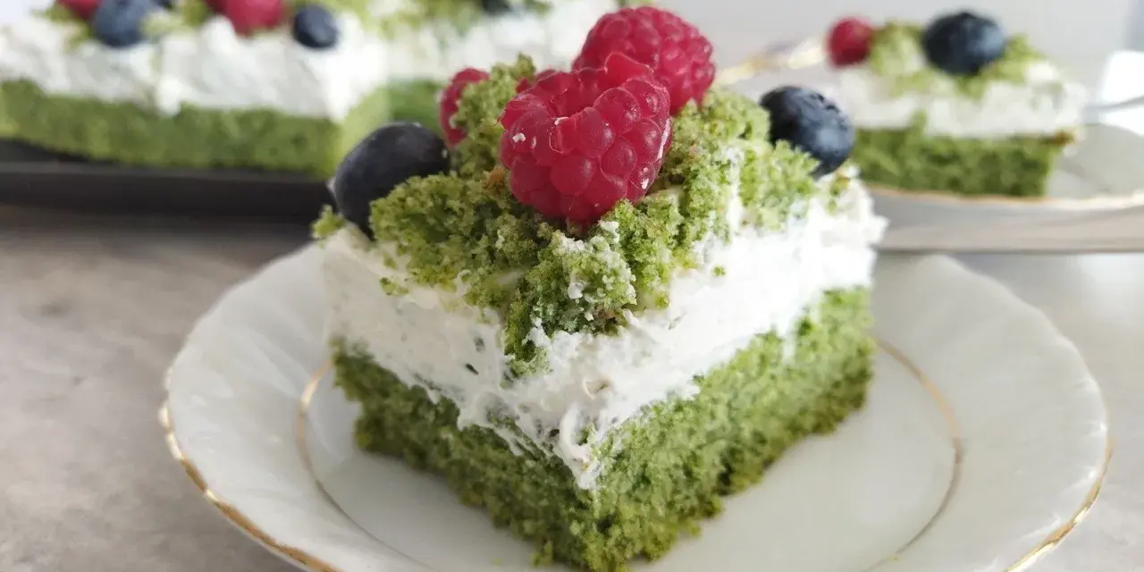 Zielony, puszysty **ciasto leśny mech na dużą blachę z serkiem mascarpone**, ozdobione malinami i borówkami.