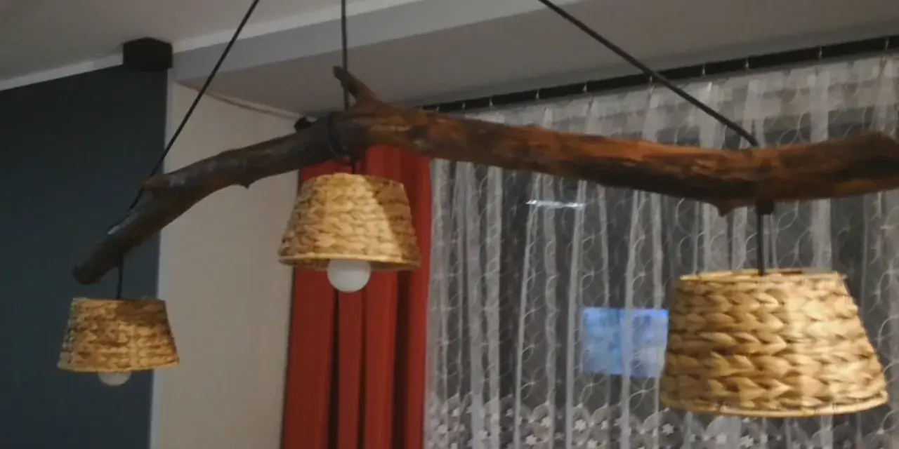 Jak odnowić stary drewniany żyrandol? Ta rustykalna lampa z gałęzi i plecionych kloszy z pewnością doda uroku wnętrzu.