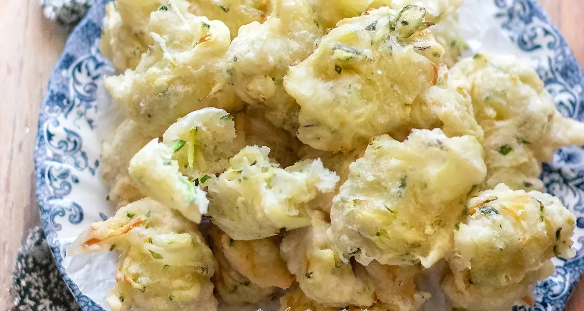 Frittelle di zucchine dolci, dorate e croccanti, servite su un piatto decorato. Un'esplosione di sapore!