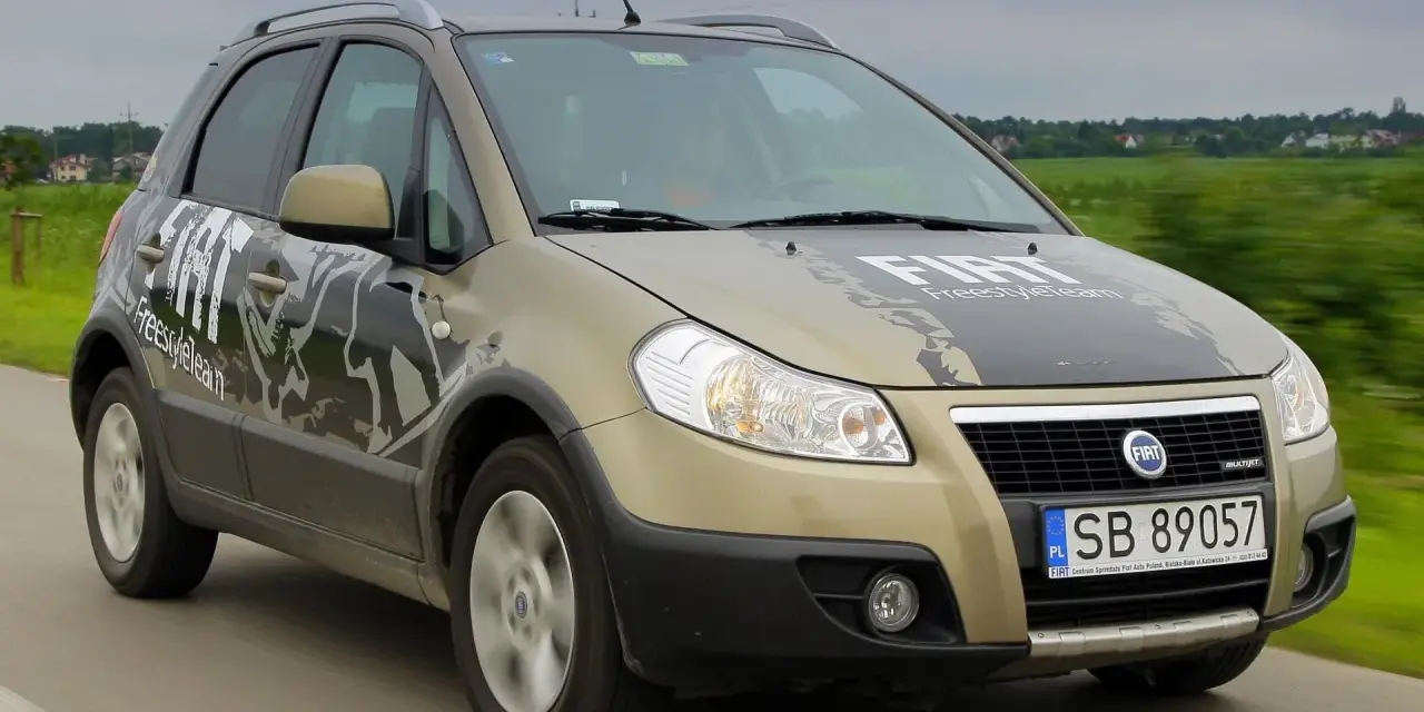 Złoty Fiat Sedici FreestyleTeam w ruchu. Wiele osób szuka opinii o tym modelu.