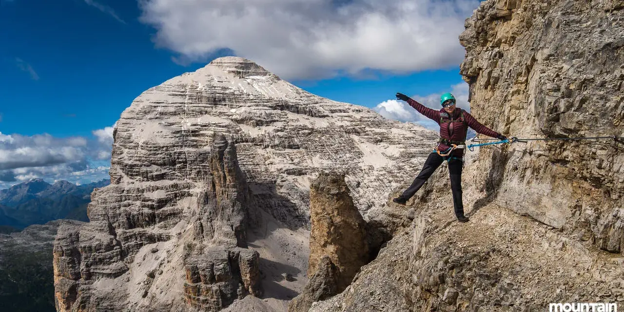Kobieta na via ferrata, pokonująca skalną ścieżkę z ubezpieczeniem. To właśnie jest ferrata co to za przygoda!