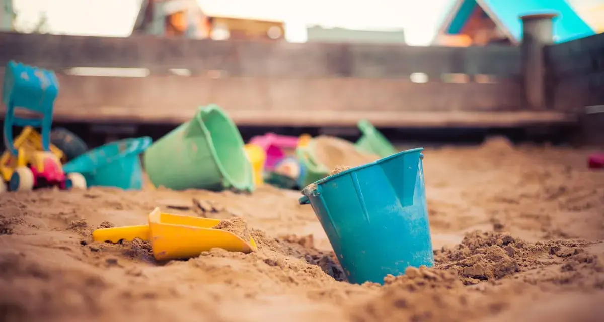 Jouets de plage dans le sable, prêts pour une demande de stage pratique BAFA.
