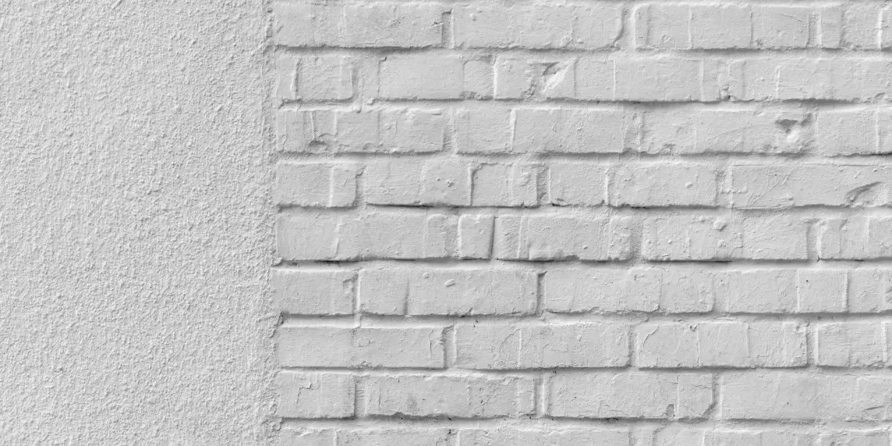 Mur blanc texturé à gauche, briques blanches à droite. Idéal pour un devis de prix piquage et rejointoiement.