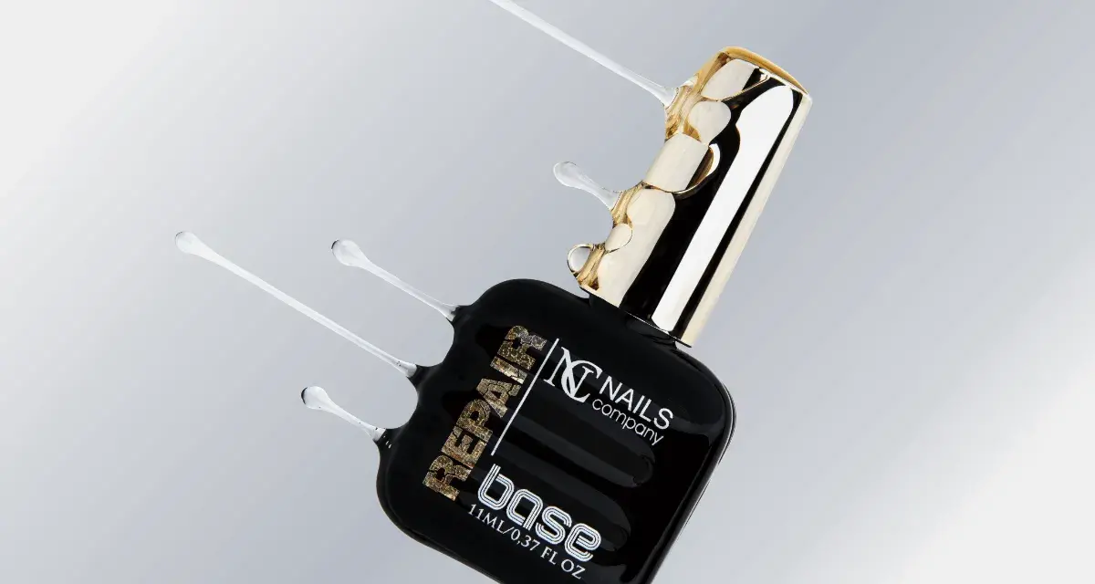 Czarna buteleczka z produktem do paznokci "base" od Nails Company, z płynnym, przezroczystym produktem wypływającym z butelki.