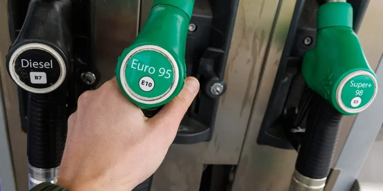 Dłoń trzymająca zielony pistolet z napisem "Euro 95 E10" przy dystrybutorze paliwa. Idealny wybór dla silnika 1.3 multijet.