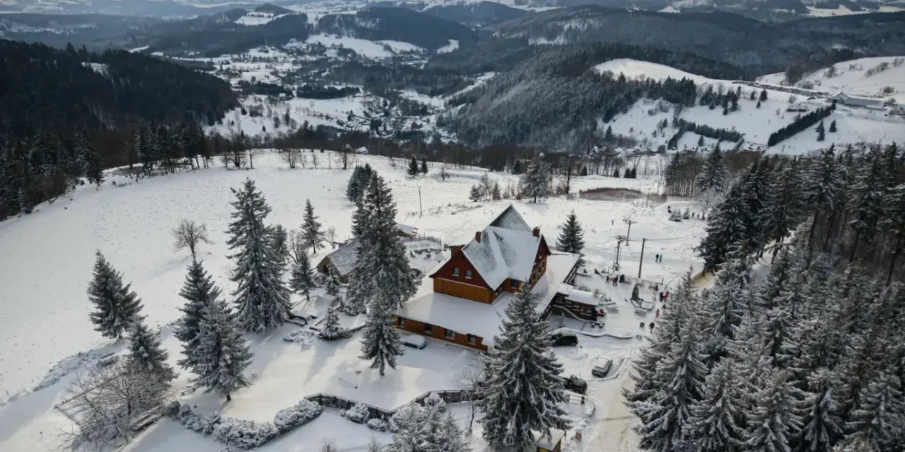 Zimowy krajobraz Dolnego Śląska, idealny na ferie zimowe 2026. Ośnieżone góry, lasy i urokliwy pensjonat.