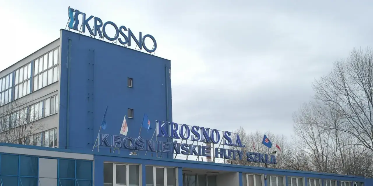 Niebieski budynek z napisem "KROSNO S.A. KROŚNIEŃSKIE HUTY SZKŁA".