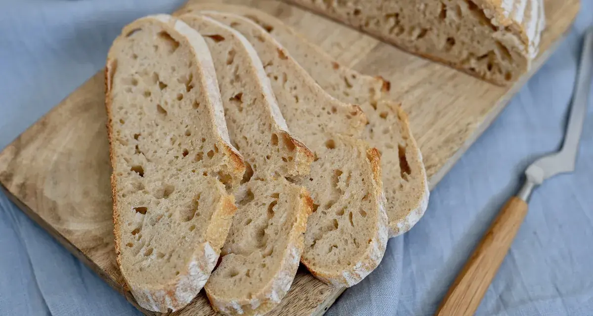 Aufgeschnittenes italienisches Brot mit Lievito Madre auf einem Holzbrett, bereit zum Genießen.