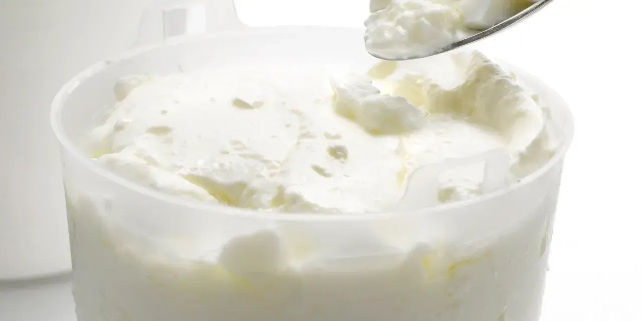 Cuillère de fromage blanc crémeux, prêt à être dégusté. La différence faisselle et fromage blanc réside dans leur texture.