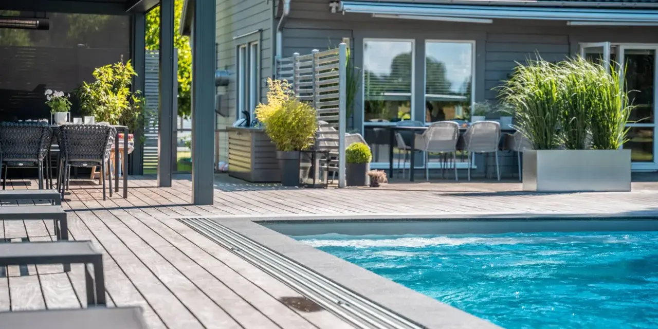 En avkopplande uteplats med pool, loungegrupp och matplats. Perfekt utedusch inspiration för sommaren.