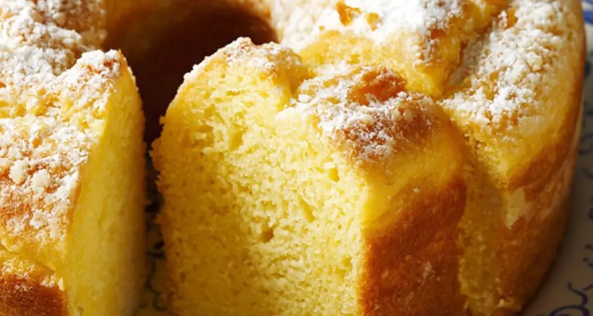 Un soffice ciambellone allo yogurt, cosparso di zucchero a velo, pronto per essere gustato.