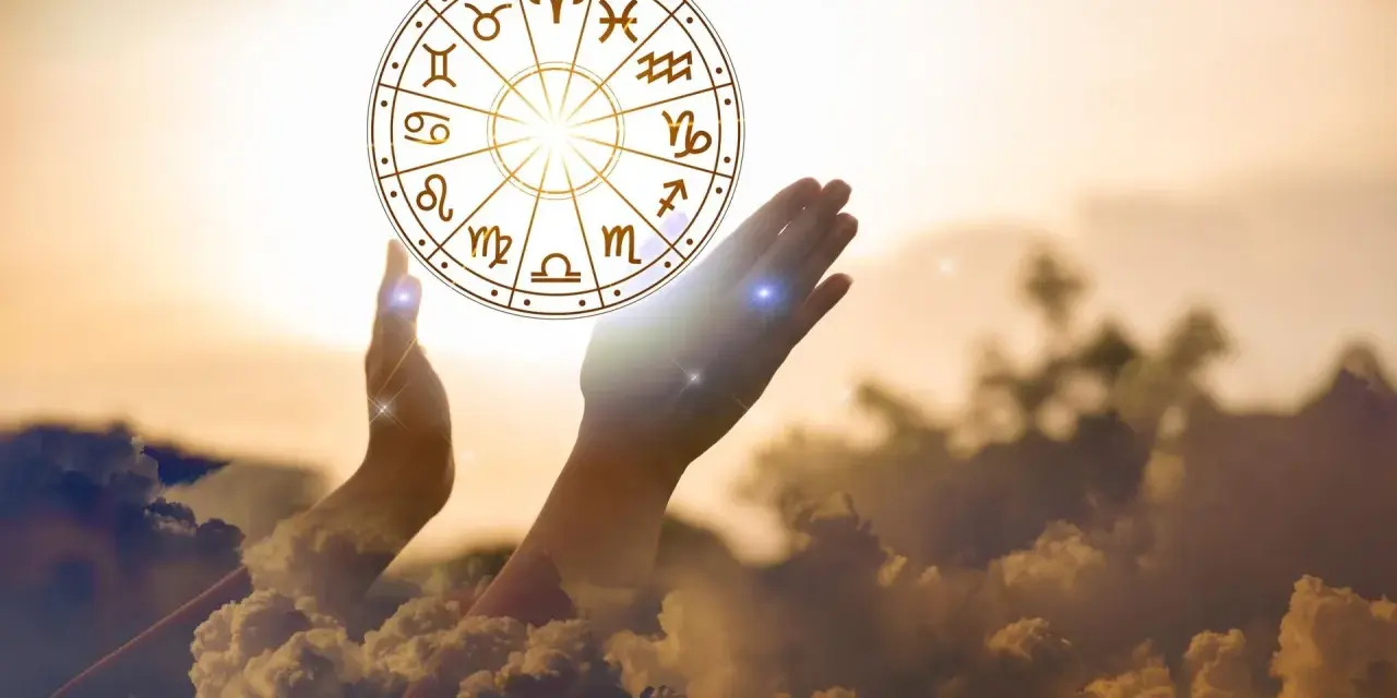 Dłonie unoszą koło zodiaku, symbolizując drogę do tego, jak obliczyć numer astrologiczny.