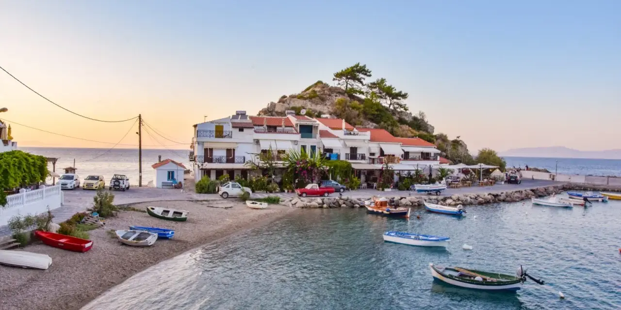 Widok na zatokę Vathy na Samos z łodziami i budynkami na tle wzgórza.