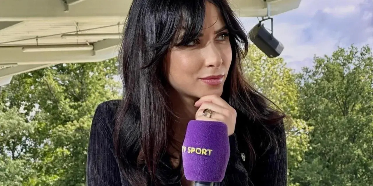 Maja Strzelczyk, dziennikarka sportowa, z mikrofonem Polsat Sport. W tle zielone drzewa i niebo.