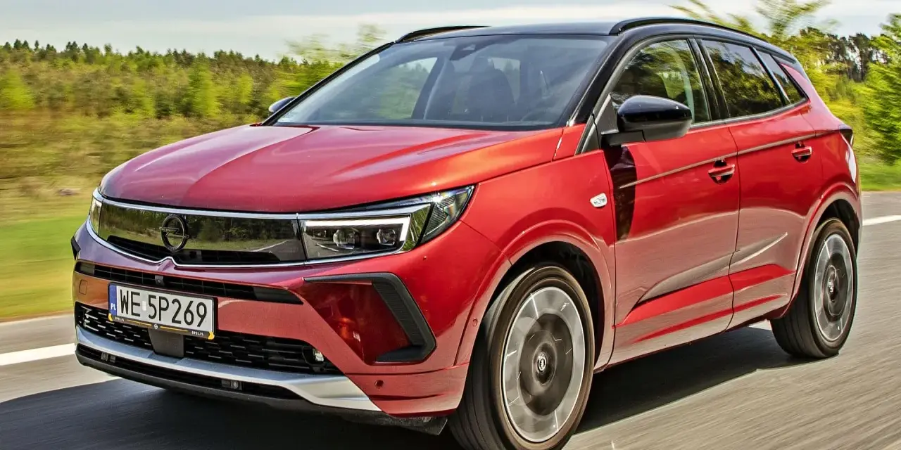 Czerwony Opel Grandland na drodze, idealny do sprawdzenia jego opel grandland cena.