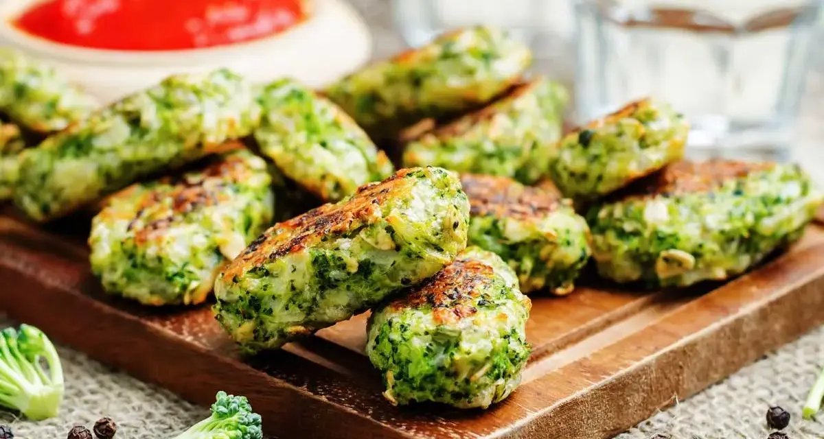 Deliciosas bolitas de brócoli, perfectas para tus recetas con brócoli. Servidas con salsa roja y un toque de pimienta.