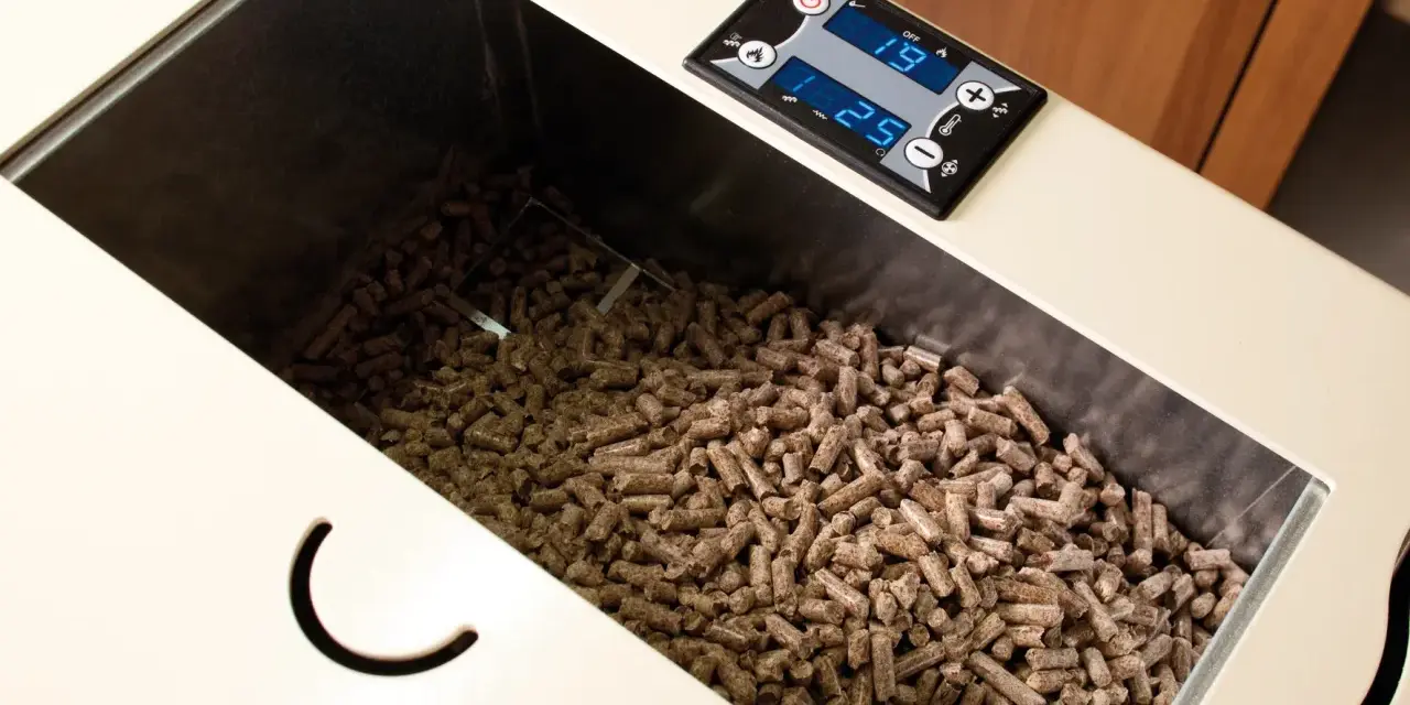 Serbatoio pieno di pellet, alcuni sembrano un po' troppo lunghi per la stufa. Il display digitale mostra 19 e 25.