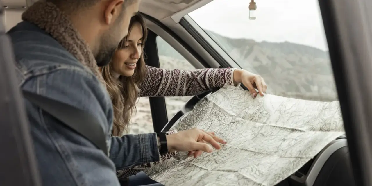 Para planować kolejny etap podróży kamperem, para przegląda mapę.