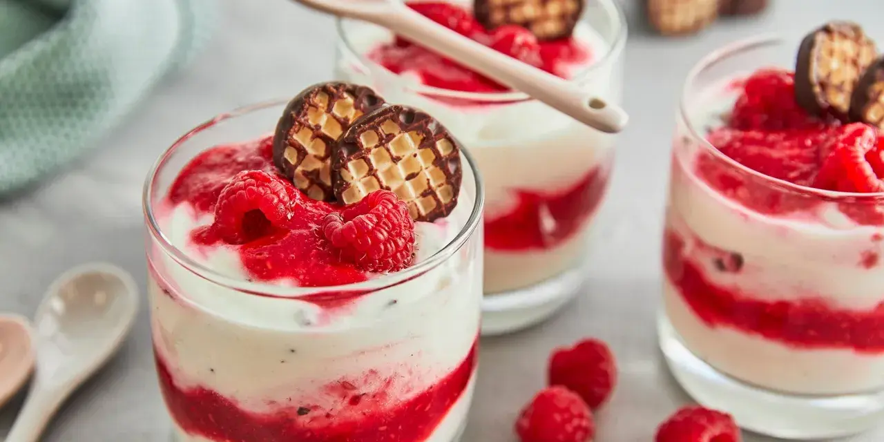 Schokokuss Dessert mit Mascarpone, Himbeeren und Schokowaffel-Keksen in Gläsern, garniert mit frischen Himbeeren.