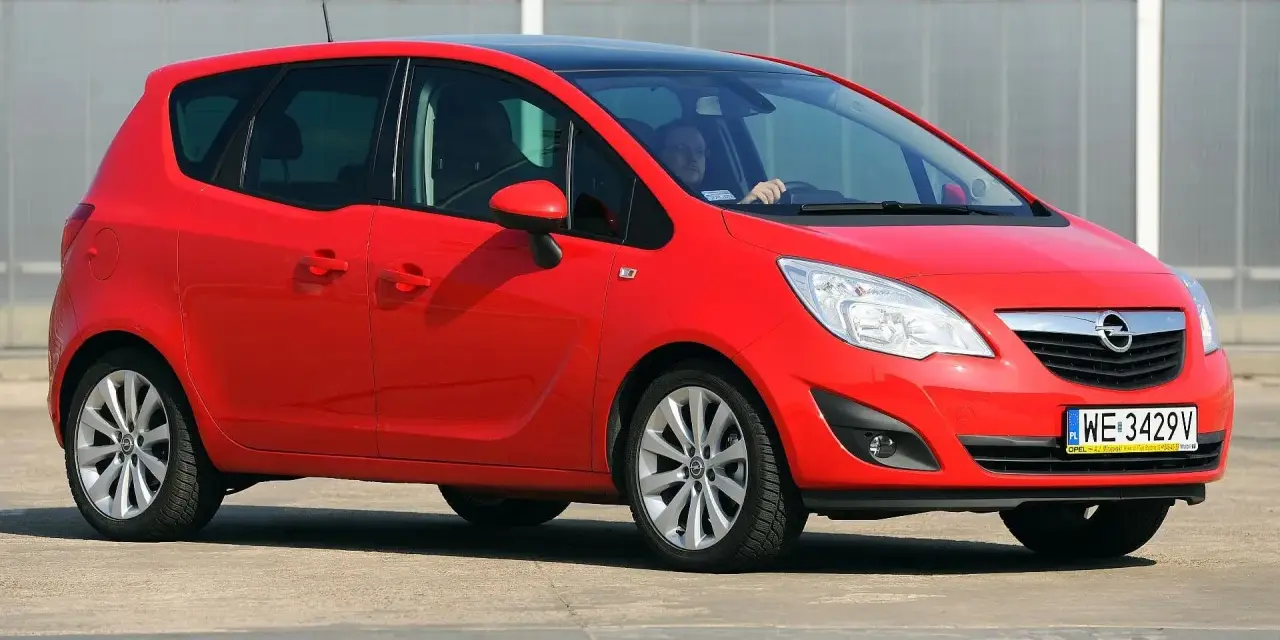 Czerwona Opel Meriva z czarnym dachem, idealna do miasta. Jaki silnik benzynowy wybrać? Ten model oferuje komfort i praktyczność.