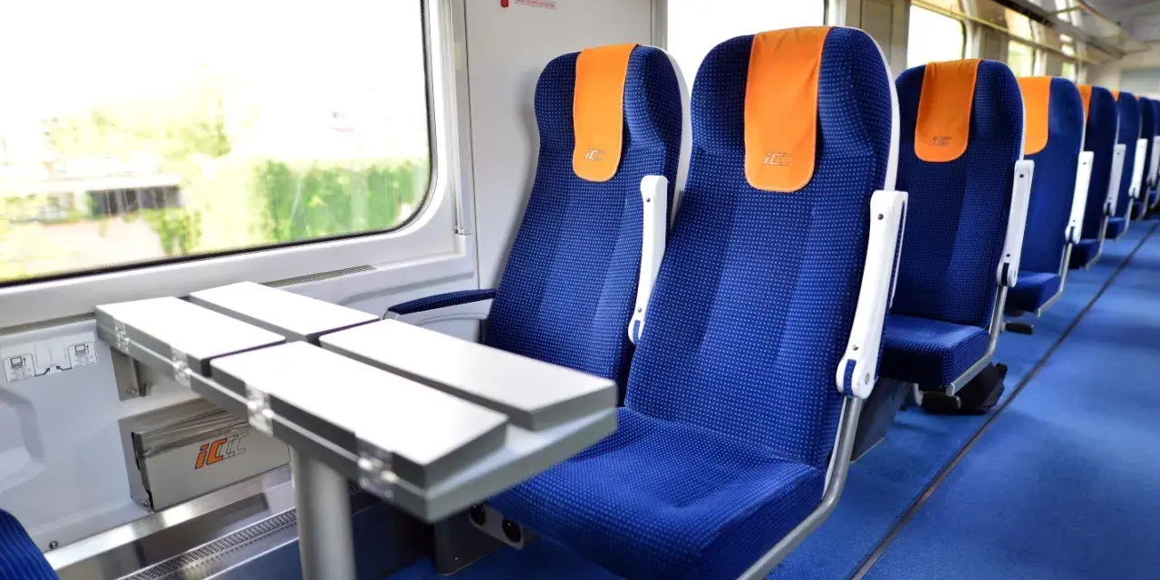 Wygodne siedzenia w pociągu PKP Intercity, gotowe na podróż do Warszawy.