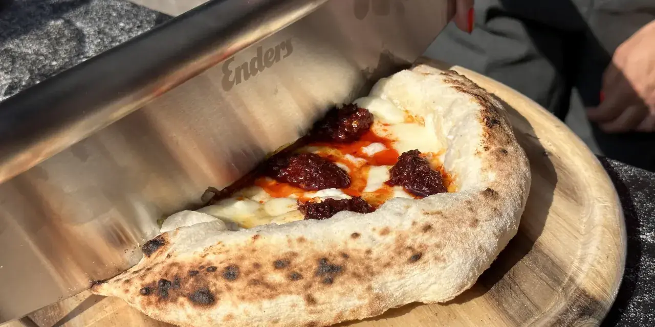 Ein Messer schneidet ein Stück Pizza mit geschmolzenem Käse und würziger Tomatensauce. Der luftige pizzateig napoli ist perfekt gebacken.