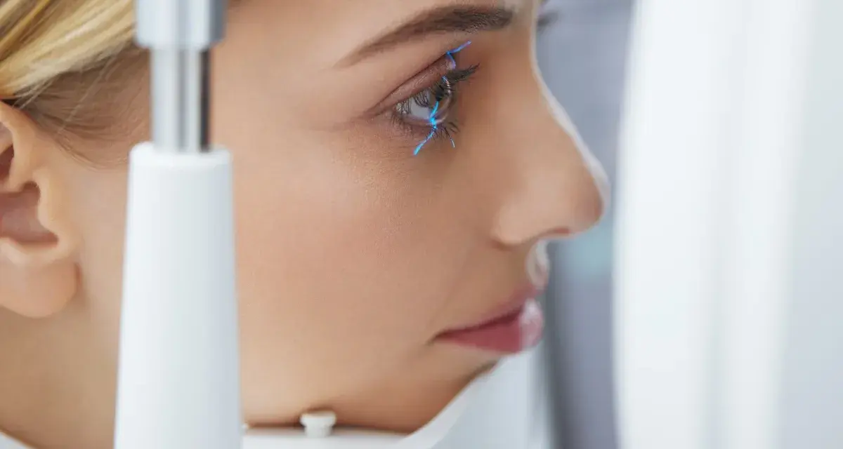 Esame oculistico: una donna con linee blu che indicano la pseudofachia dell'occhio.