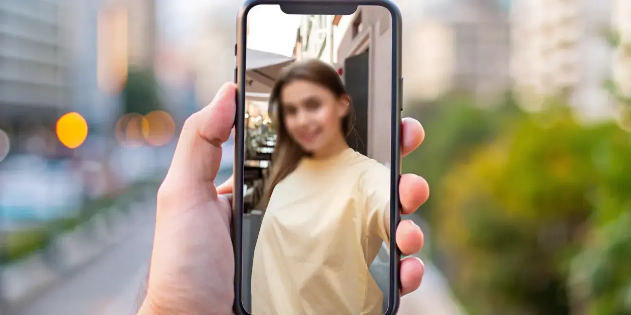 Chcesz wiedzieć, jak zamazać twarz na zdjęciu iPhone? Na ekranie telefonu widać rozmazaną twarz młodej kobiety.