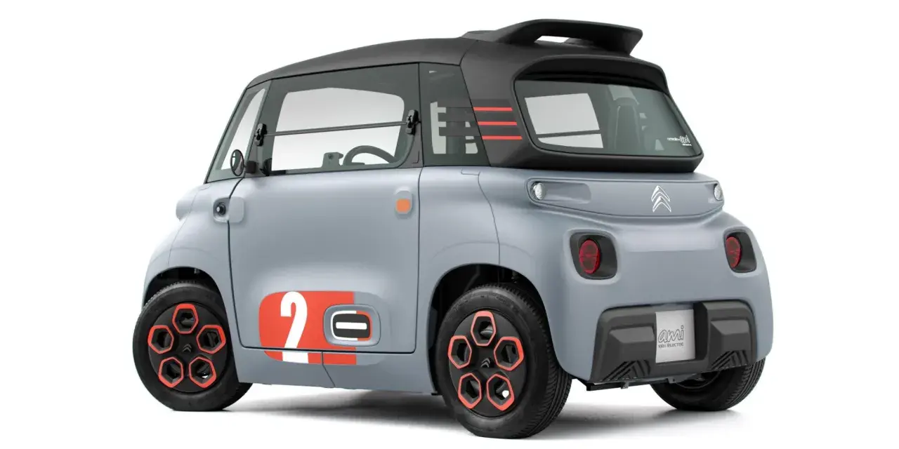 Szary Citroen Ami z pomarańczowymi akcentami i numerem 2. Ten elektryczny pojazd oferuje zaskakujący zasięg na jednym ładowaniu.