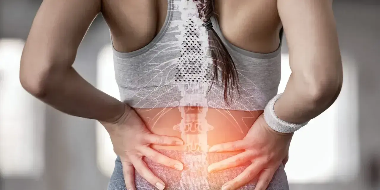 Kobieta z bólem w odcinku lędźwiowym kręgosłupa, wskazującym na dyskopatię lędźwiową i jej objawy neurologiczne.