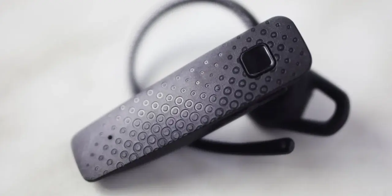 Czarna słuchawka Bluetooth z wytłoczonym wzorem kółek. Dowiedz się, jak sparować ją z telefonem.