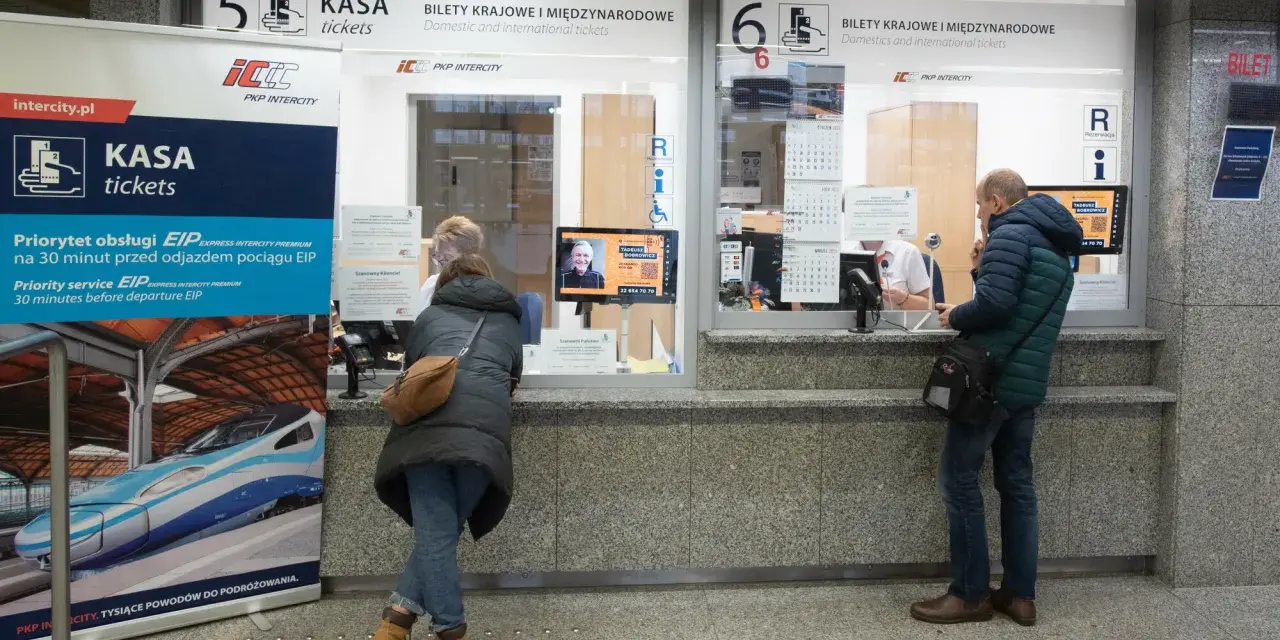 Kasa PKP Intercity w Poznaniu, gdzie kupisz bilety na pociąg do Warszawy. Ludzie stoją w kolejce do okienka.