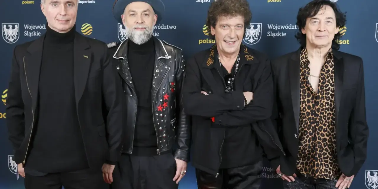 Czterech mężczyzn, w tym legendy polskie zespoły muzyczne lat 70-80, pozuje na ściance.