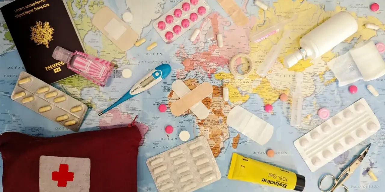 Une trousse de secours prête pour un voyage autour du monde : passeport, pansements, thermomètre, pilules, désinfectant et crème.